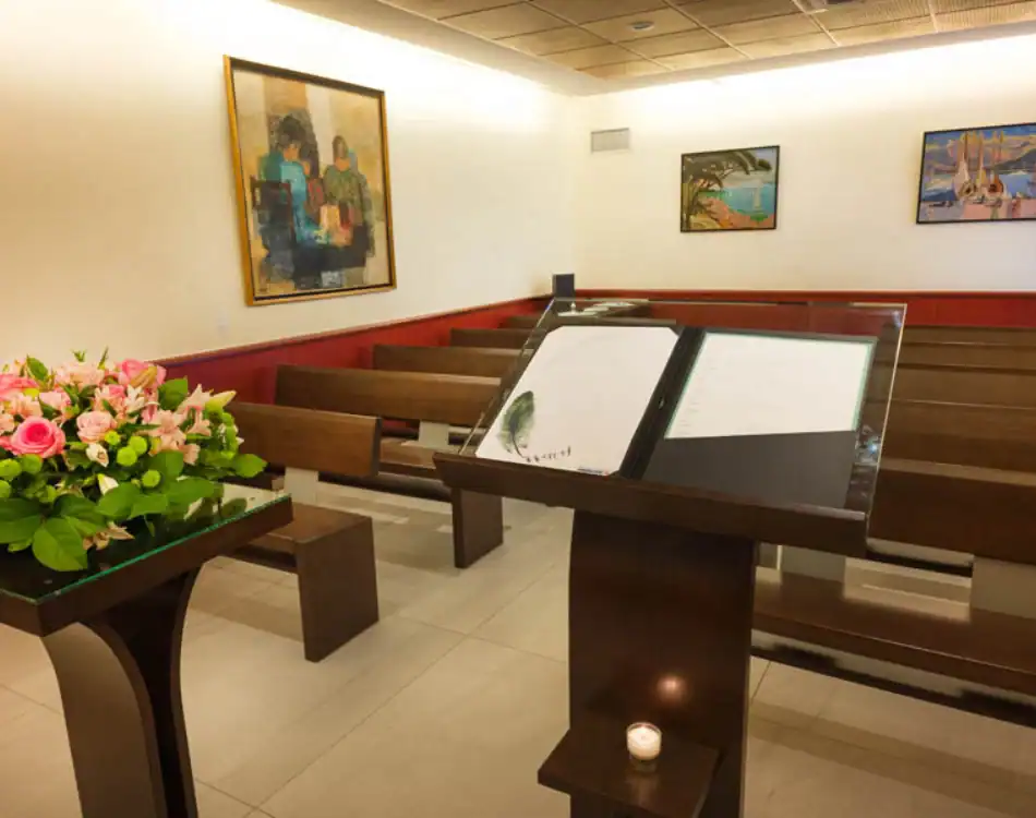 CPL-Salles-Bigot-1 Salle de cérémonie avec pupitre, registre de condoléances, bancs en bois et composition florale au crématorium