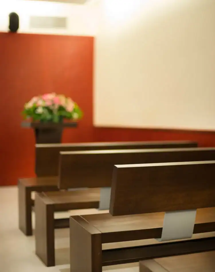 CPL-Salles-Bigot-3 Bancs en bois alignés dans une salle de cérémonie avec composition florale en arrière-plan