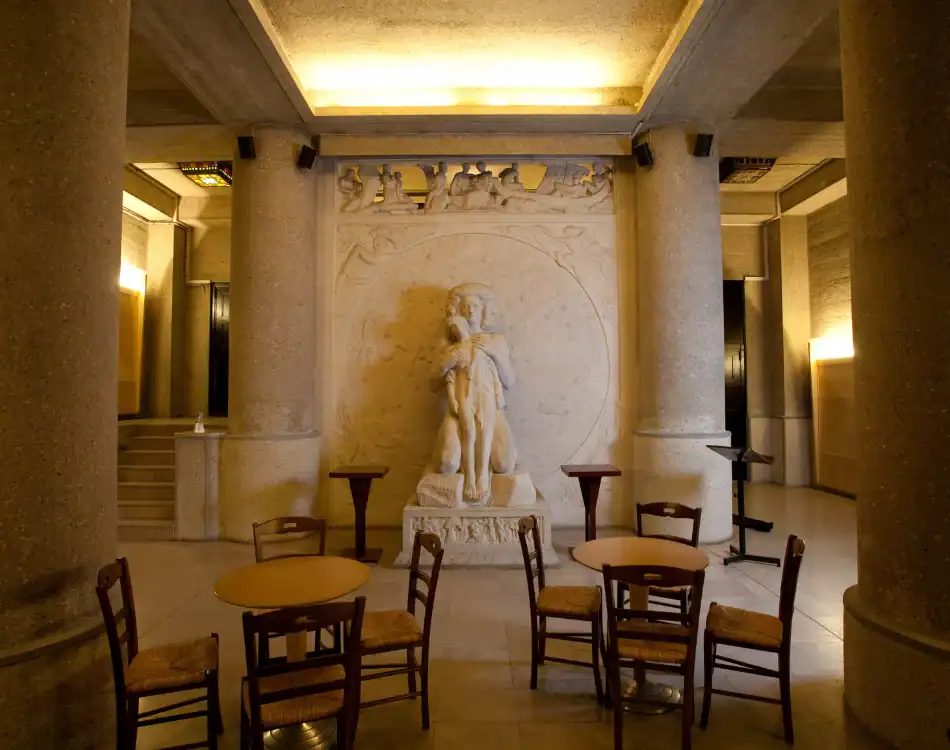 CPL-Salles-Landowski-1 Espace de recueillement avec statue centrale, colonnes en pierre et assises, dans une atmosphère chaleureuse et solennelle