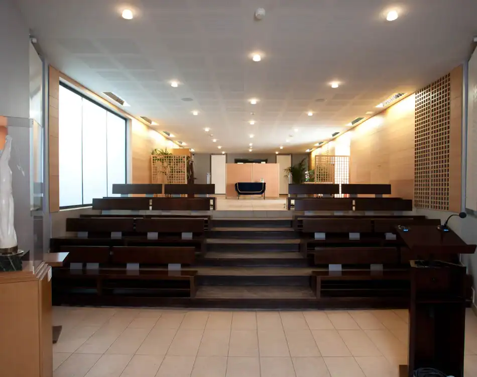 CPL-Salles-Mauméjean-2 Salle de cérémonie lumineuse du crématorium du Père-Lachaise avec gradins en bois et espace central pour l’hommage