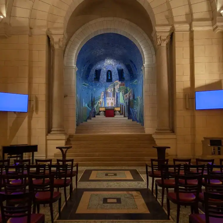 CPL-image-les-espaces-de-ceremonie Salle de cérémonie majestueuse avec voûtes en pierre et mosaïque bleutée en arrière-plan, offrant un cadre solennel et apaisant pour les hommages