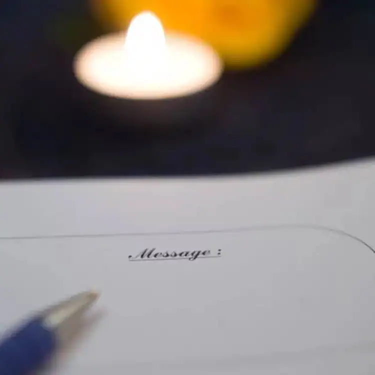 CPL-image-rituels-et-personnalisation Registre de condoléances ouvert avec espace “Message”, accompagné d’une bougie, invitant à écrire un dernier mot en toute intimité